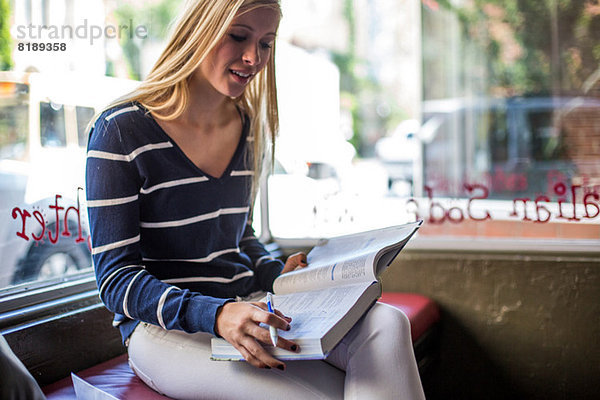 Teenager-Mädchen studiert im Cafe