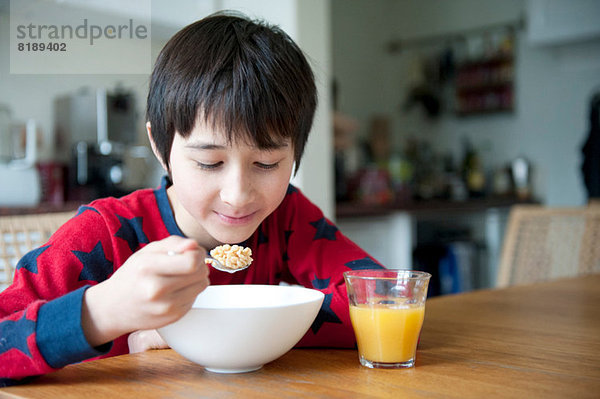 Junge isst Frühstückscerealien bei Tisch