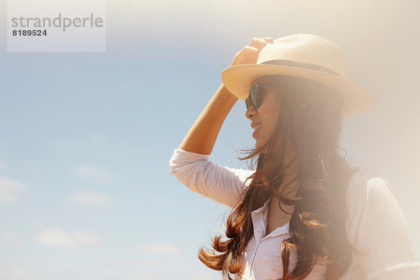 Junge Frau mit Sonnenhut und Sonnenbrille