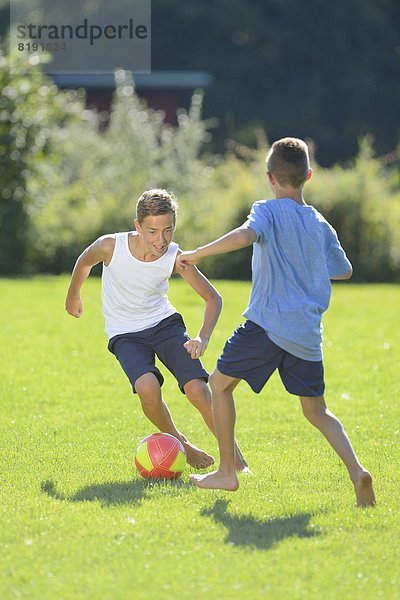 Zwei Teenager spielen Fußball auf der Wiese  Oberpfalz  Bayern  Deutschland  Europa