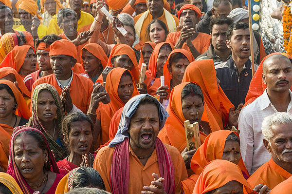 Prozession von in orangener Farbe gekleideten Gläubigen  während der Kumbha Mela