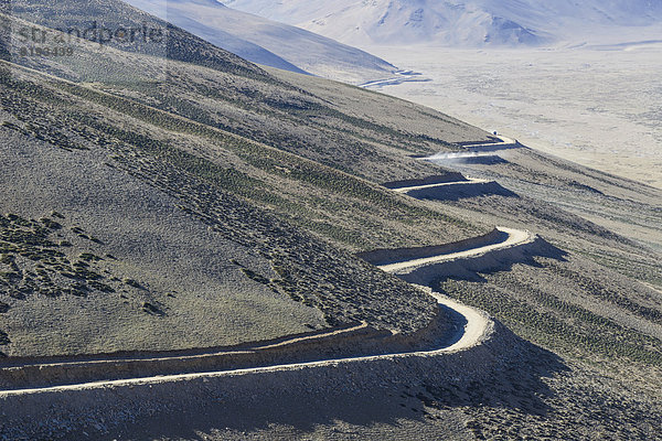 Eine kurvenreiche Straße führt zum Gebirgspass Taglang La  5325 m  dem höchsten Pass auf dem Manali-Leh Highway