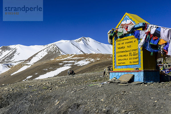 Meilenstein auf dem Gebirgspass Taglang La  5325 m  dem höchsten Pass auf dem Manali-Leh Highway  schneebedeckte Berge hinten