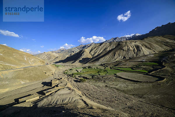 Kleines Dorf mit grünen Wiesen in einer kargen Landschaft auf 4000 m Höhe