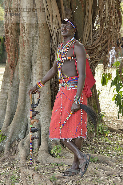 Massai-Krieger in traditioneller Kleidung und in typischer Haltung auf einem Bein
