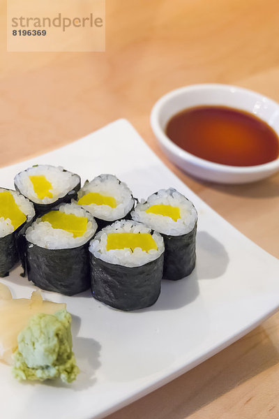 Sushi-Rollen mit gepflücktem Rettich in Reis auf Teller  Nahaufnahme