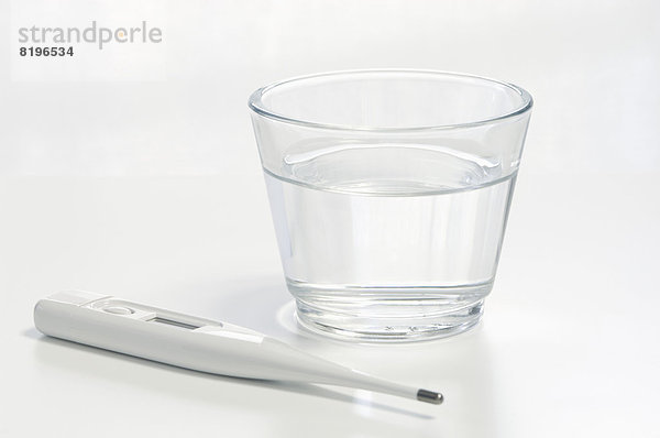 Klinisches Thermometer mit Wasserglas  Nahaufnahme