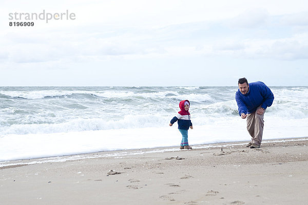 Vater mit seiner Tochter am Strand