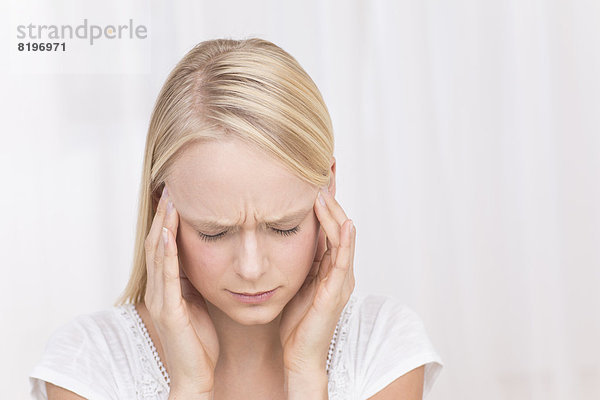 Junge Frau mit Kopfschmerzen  Nahaufnahme
