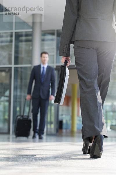 Businessman and businesswoman walking with briefcase at terminal