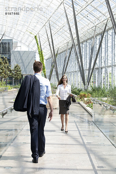 Businessman and businesswoman walking at modern office building