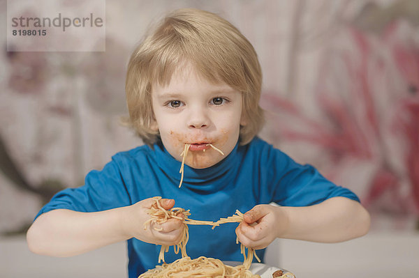 Portrait of boy eating spaghetti