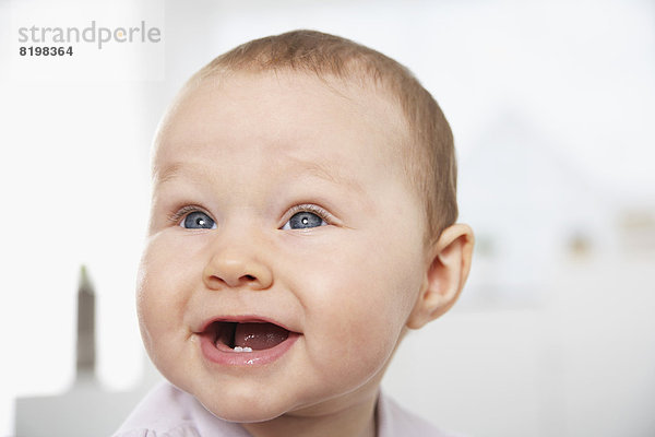 Deutschland  Nordrhein-Westfalen    Baby Mädchen schaut weg  lächelnd