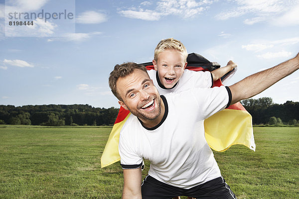 Germany  Cologne  Father and son cheering in football outfit