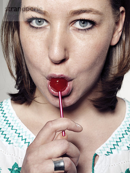Portrait of Young woman licking lollipop  close up