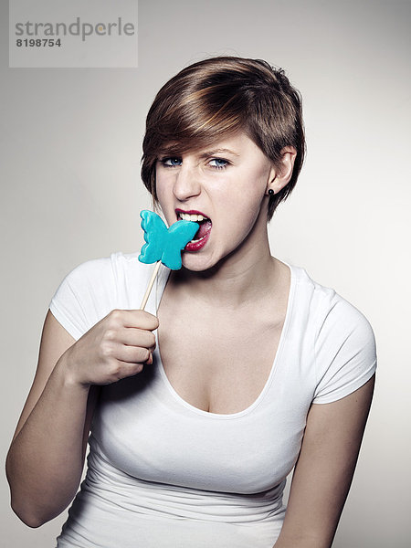Portrait of Young woman holding lollipop  close up mouth