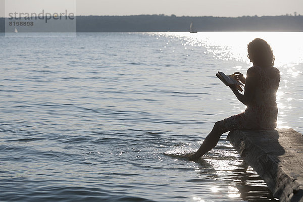 Mature woman reading book at Lake Stamberg