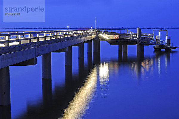 Seebrücke  beleuchtet  in der Abenddämmerung