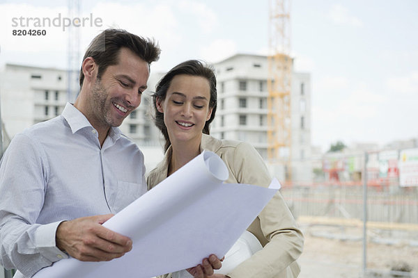 Architekten prüfen Bauplan auf der Baustelle