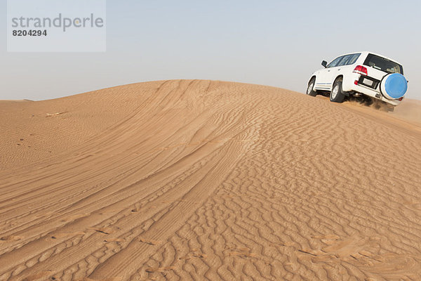 Sports Utility Vehicle beim Auffahren der Wüstensanddüne