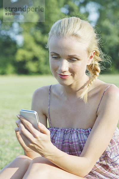 Junge Frau mit Smartphone im Freien