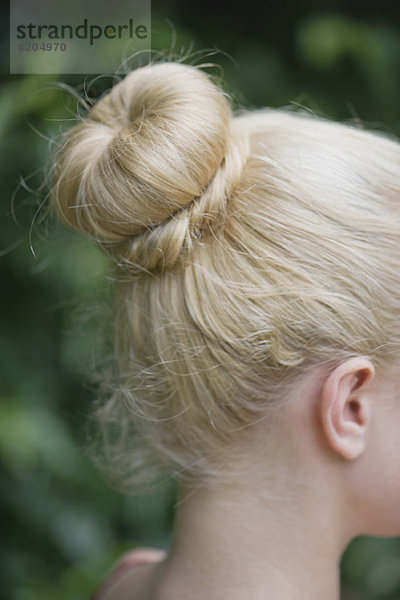 Frauenhaar in einem Chignon arrangiert