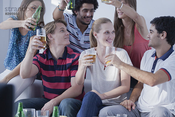 Freunde  die sich im Fernsehen ein Sportspiel anschauen  feiern gemeinsam