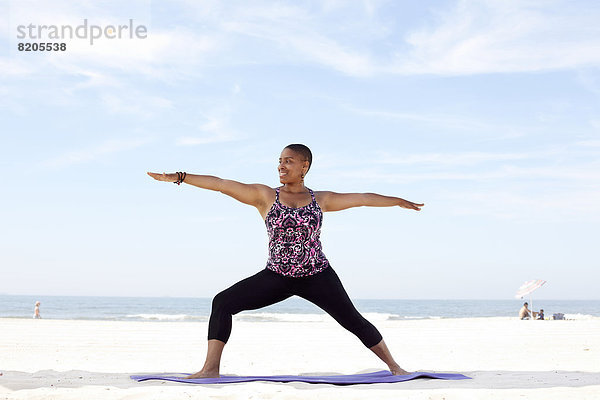 Frau üben Yoga am Strand