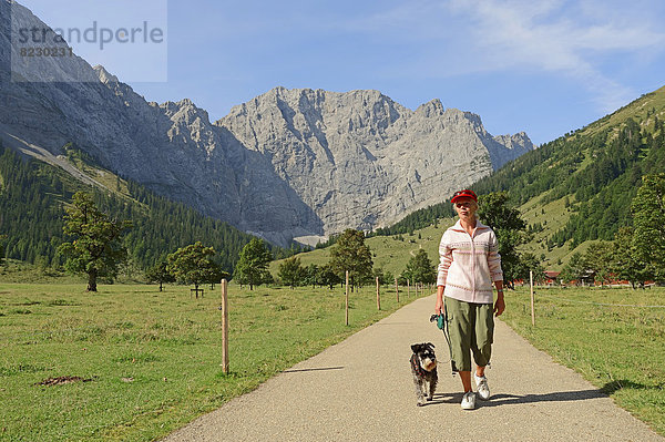 Frau mit Zwergschnauzerbeim Wandern  Engalm  vor Karwendel-Gebirge