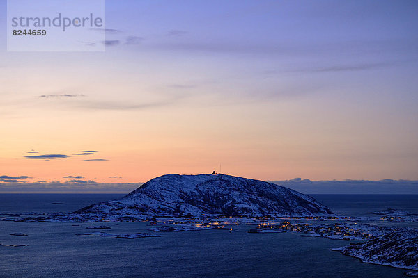 Fjord mit Bergen im Winter zum Sonnenuntergang