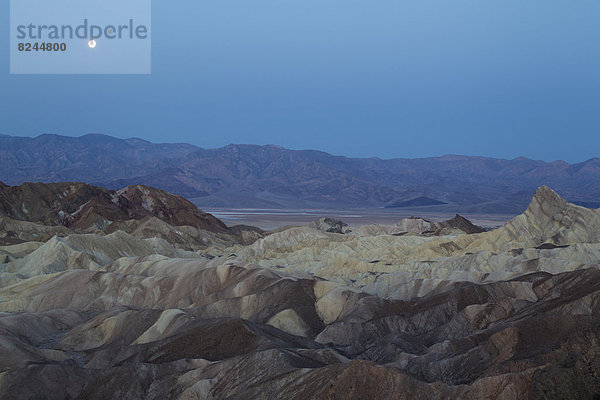 Die Einöde von Gower Gulch mit der Manly Beacon Felsspitze rechts  hinten Death Valley und Panamint-Gebirge  in der Morgendämmerung mit Vollmond