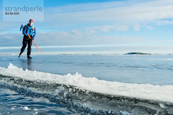 Man ice-skating  sea in foreground