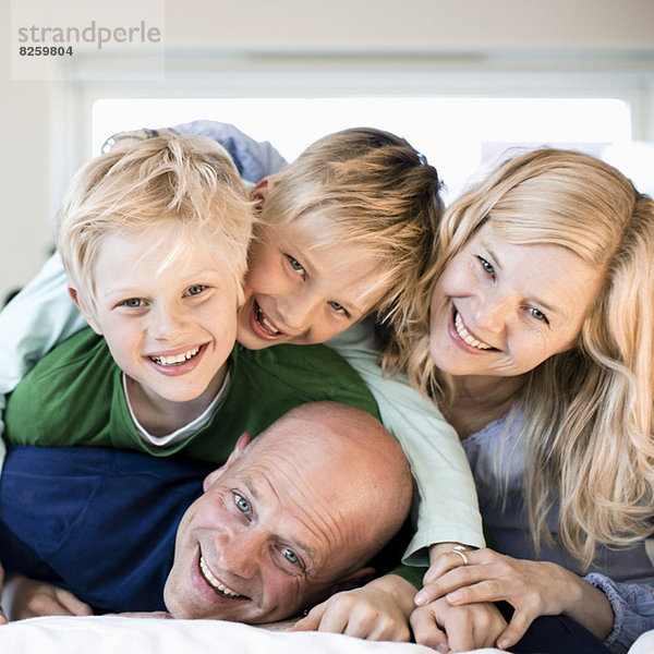 Porträt einer glücklichen Familie im Bett