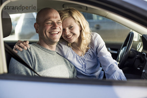 Porträt einer glücklichen Frau mit Mann im Auto