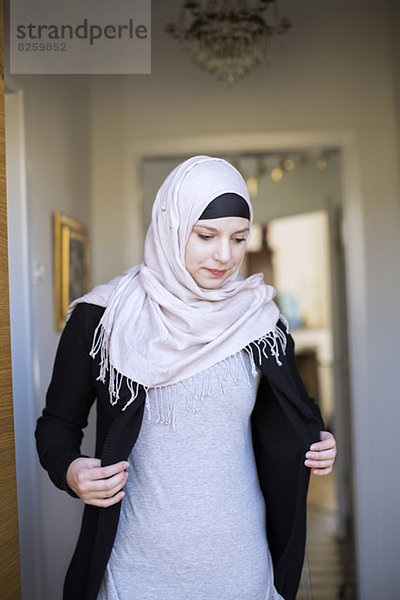Junge muslimische Frau mit einem Hijab zu Hause