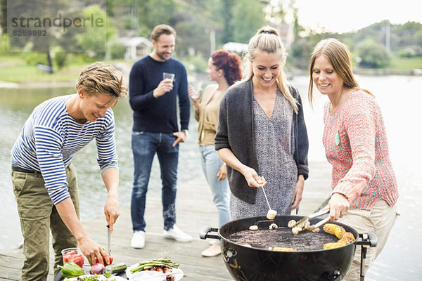 Gruppe von Freunden beim Grillen am Pier