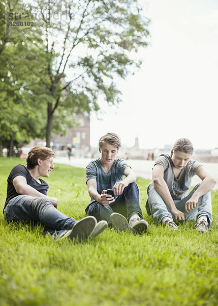 Männliche Freunde entspannen sich auf Rasen im Park