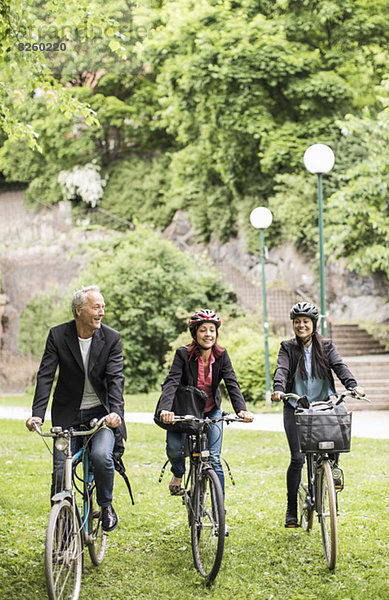 Geschäftsleute mit Fahrrädern im Park