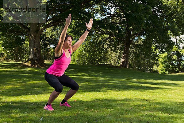 Frau macht eine Dehnübung im Park