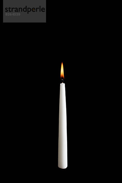 Brennende Kerze auf schwarzem Hintergrund