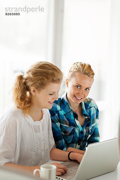 Zwei junge Frauen arbeiten auf laptop