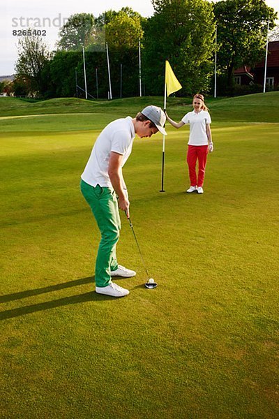 Junges paar Golf zu spielen