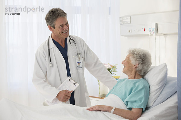 Arzt im Gespräch mit älteren Patienten im Krankenhaus