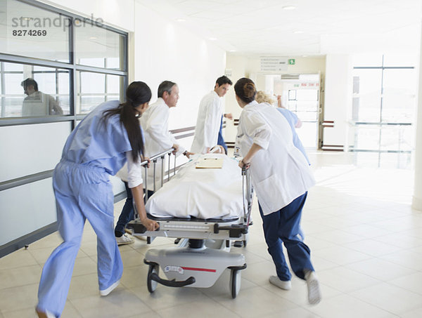 Ärzte hetzen Patienten auf Bahre den Krankenhausflur hinunter
