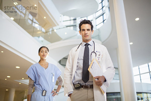 Porträt des selbstbewussten Arztes und der Krankenschwester im Krankenhausatrium