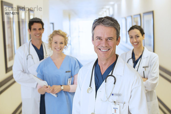Porträt von lächelnden Ärzten und Krankenschwestern im Krankenhausflur