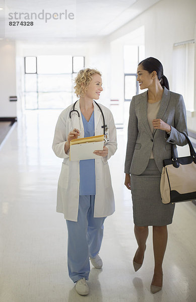 Ärztin und Geschäftsfrau beim Spaziergang im Krankenhausflur