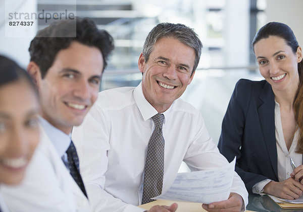 Porträt von lächelnden Ärzten und Geschäftsleuten in der Sitzung