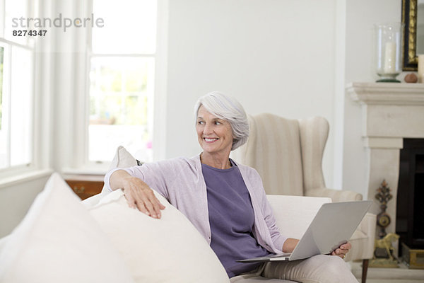 Senior Frau mit Laptop auf dem Sofa