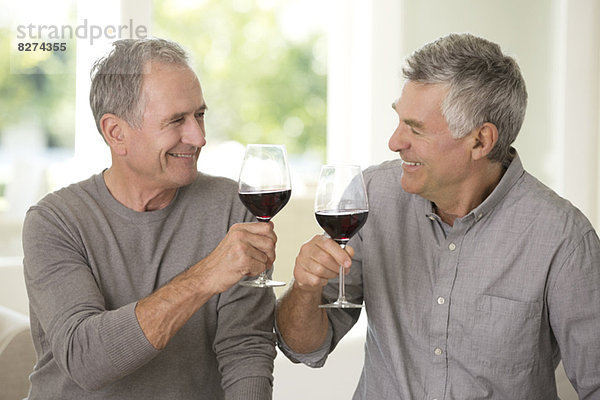 Senior Männer toasten Weingläser
